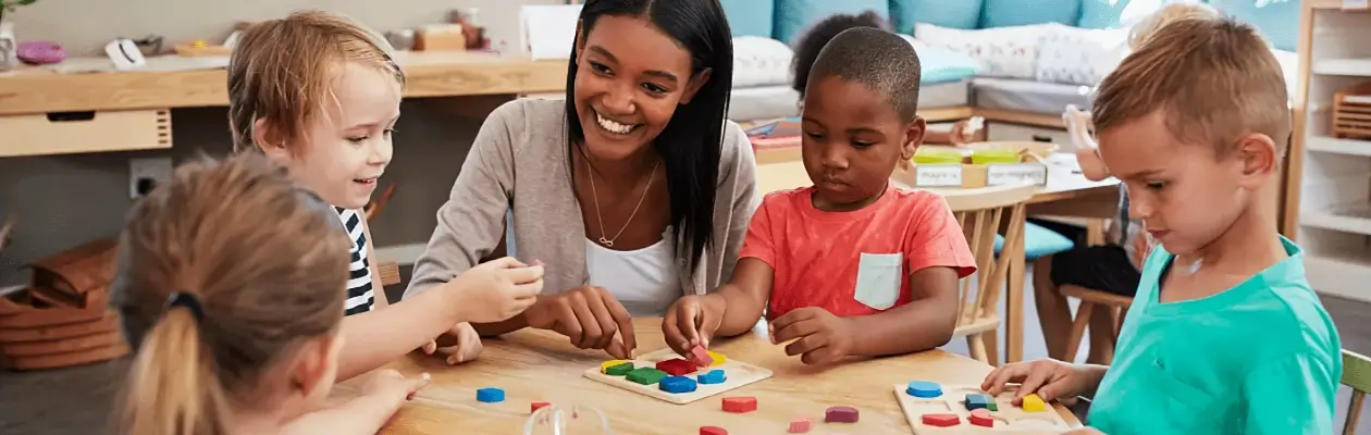 Un groupe d'enfants apprentis en jouant à une table dans une salle de classe.